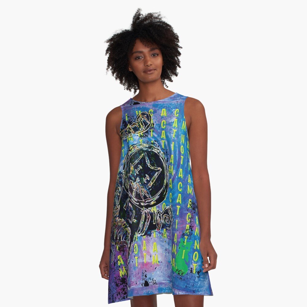 A woman wears an a line dress featuring a cute cat print.